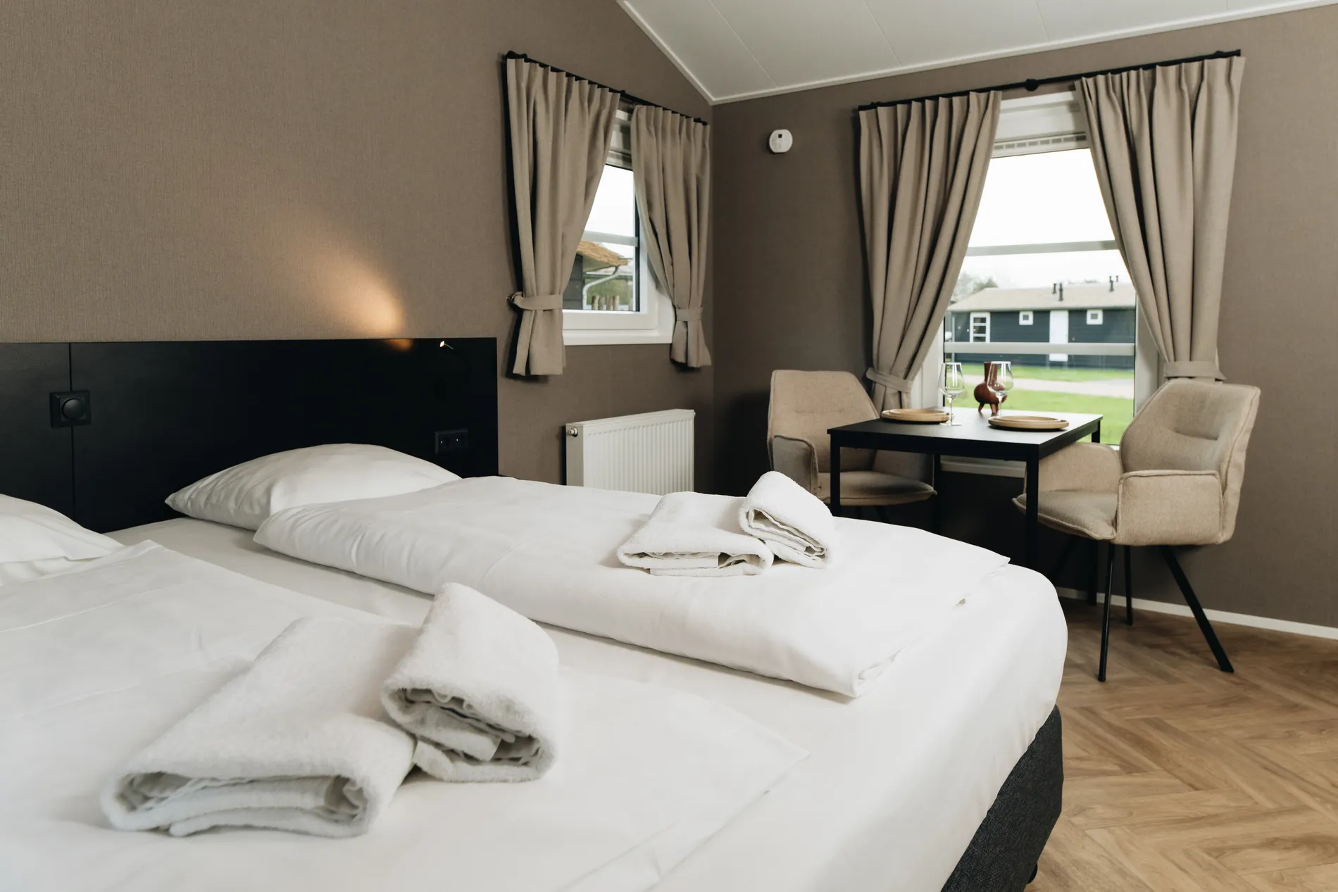 Overzicht van een moderne studio bij Resort Land & Zee met een opgemaakt bed, zithoek en sfeervolle eethoek.